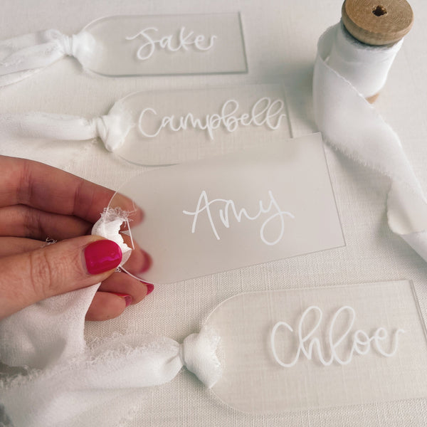 Arch acrylic tags with names written in white ink white ribbon