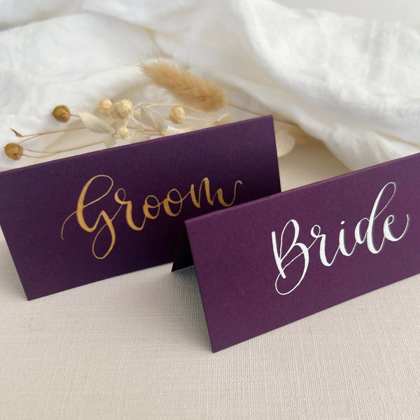 Purple place card with name written in gold ink calligraphy 