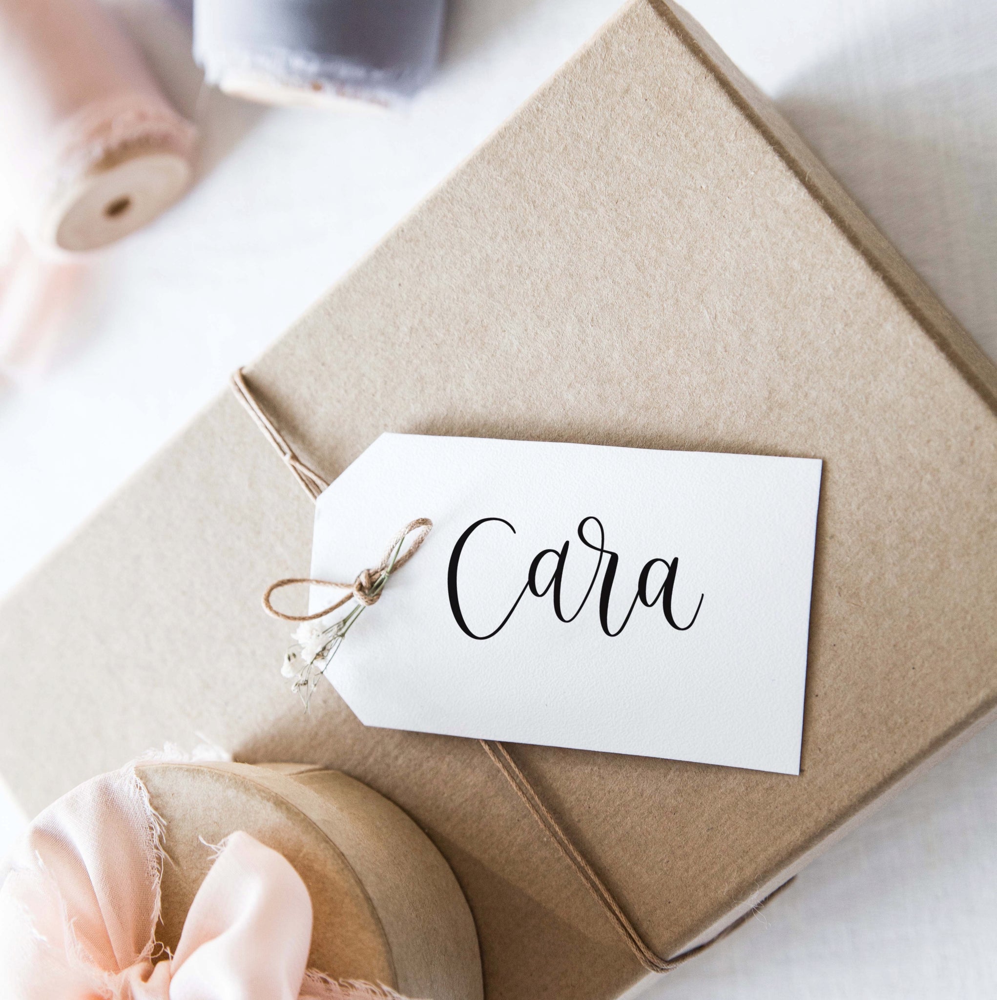 Calligraphy place card attached to a gift box with twine